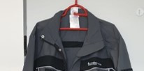 A gray work jacket with black appliqués
